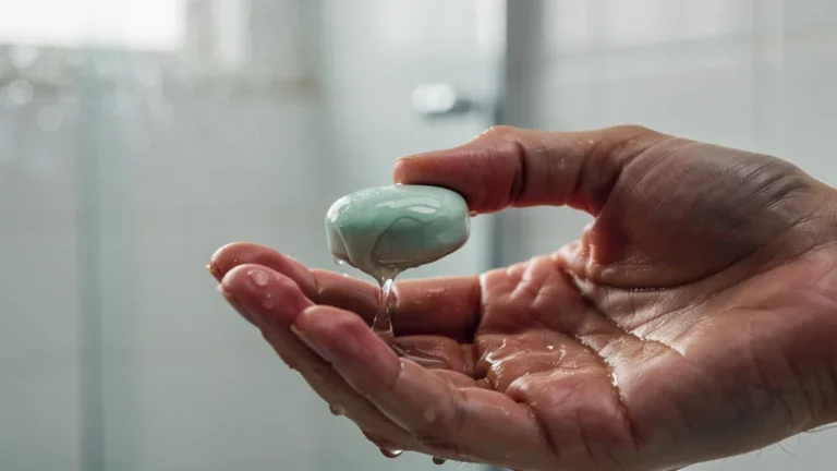 Gros plan hyperréaliste d'un dentifrice solide fondant entre les doigts avec gouttes et texture détaillée